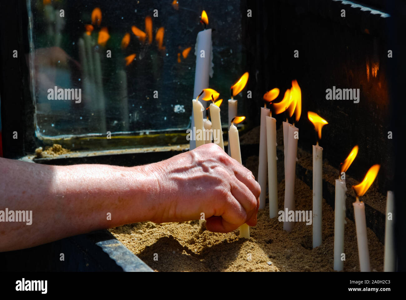 Donna mette mano il flaming cero nella chiesa. La religione. Foto Stock