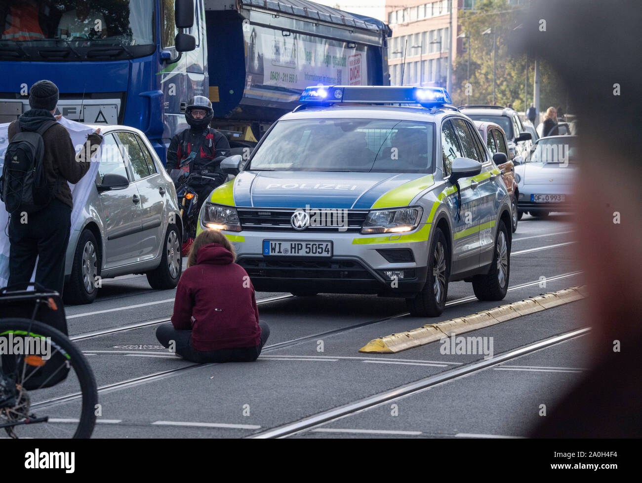 Il 20 settembre 2019, Assia, Frankfurt/Main: dimostranti di vari gruppi di azione di bloccare il traffico su Baseler Platz; un dimostrante è seduto sulla corsia nella parte anteriore di una macchina della polizia. I dimostranti seguire la chiamata del movimento il venerdì per il futuro e vogliono lottare per di più la protezione del clima. Essi vogliono supportare le chiamate per gli scioperi e manifestazioni di protesta in tutto il mondo. Foto: Boris Roessler/dpa Foto Stock