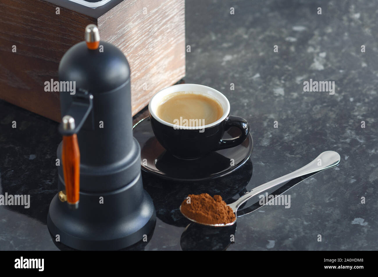 Caffettiera tipo geyser e colorati di nero tazza da caffè con i chicchi di caffè e caffè appena macinato in un cucchiaio. Foto Stock
