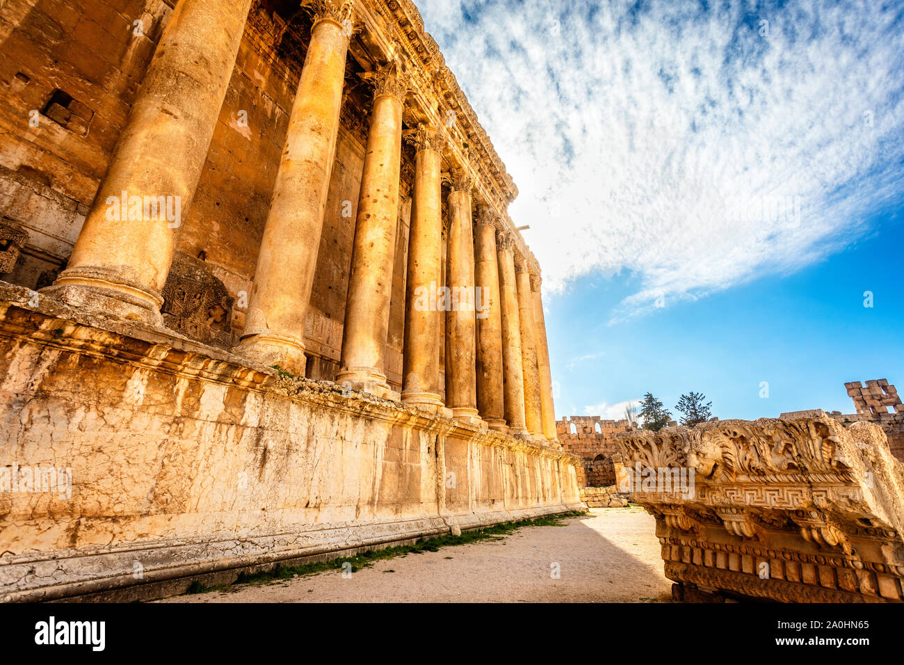 Colonne di antico tempio romano di Bacco con rovine circostanti e cielo blu in background, Beqaa Valley, Baalbeck, Libano Foto Stock