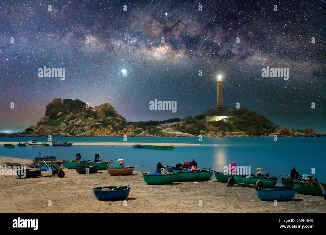 La notte vista al mare villaggio di pescatori che si trova accanto al faro brilla nel cielo e la galassia è bello Foto Stock