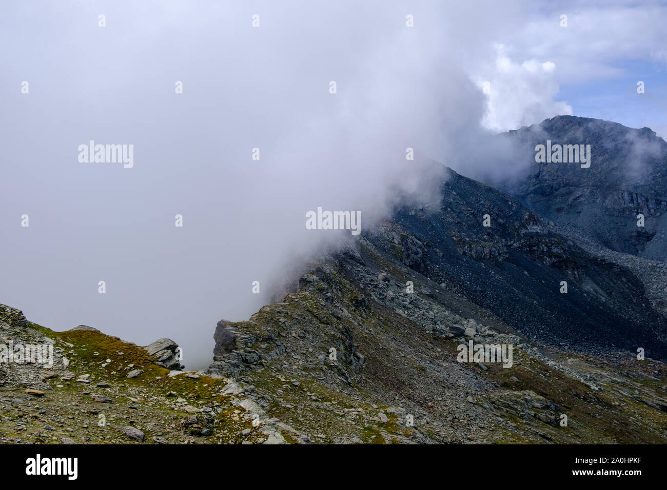 nuvole che si innaliscono da un crinale di montagna, alpi italiane Foto Stock