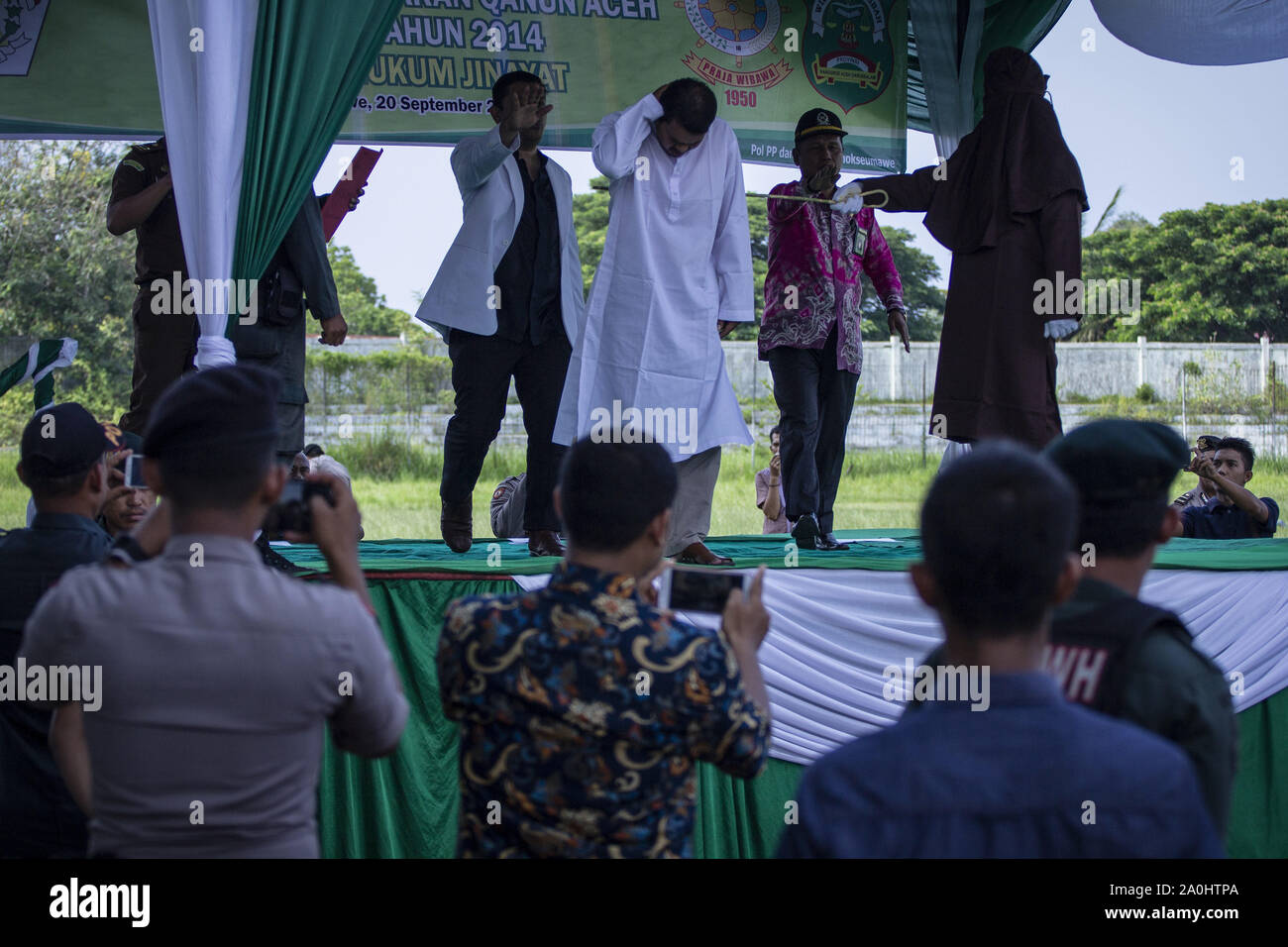 Lhokseumawe, Aceh, Indonesia. Xx Settembre, 2019. I funzionari che hanno testimoniato interrompere la frase originari effettuata da funzionari della Sharia perché il collo di un uomo che è stato catturato avere un affare con la moglie di qualcun altro grimaced sofferto dolori durante una frase originari a uno stadio in Lhokseumawe, nella provincia di Aceh. La coppia che sono stati catturati avente un affare sono stati frustati per 9 volte ognuna per violare la legge islamica nella provincia di Aceh che è la più conservativa provincia della legge islamica in Indonesia. Credito: Zikri Maulana/ZUMA filo/Alamy Live News Foto Stock