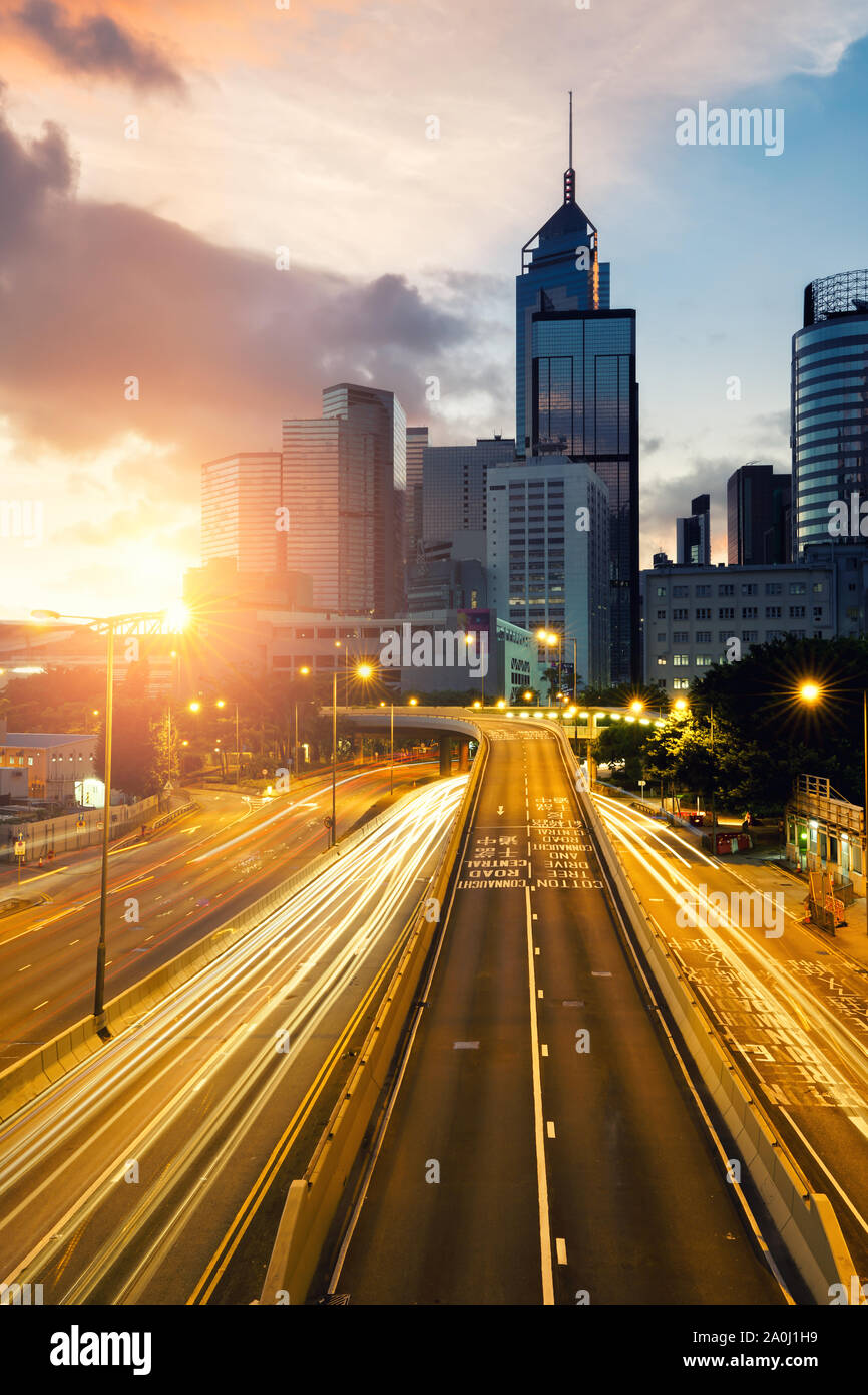 Sentieri di luce del traffico di Hong Kong al tramonto del tempo con Hong Kong bussines center in background. Asia. Asian Tourism, città moderna vita o business f Foto Stock