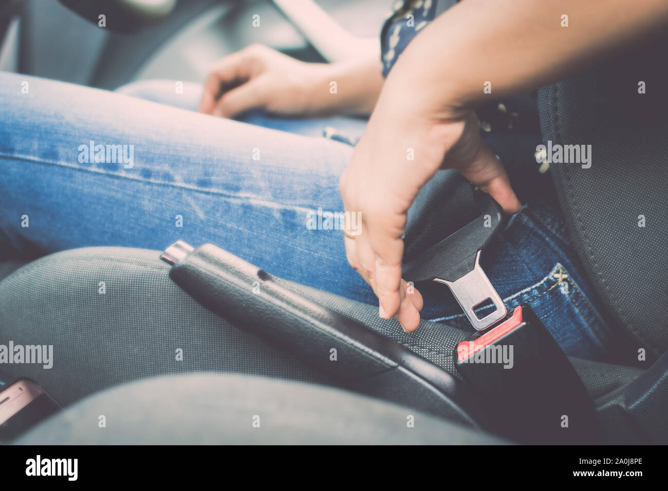 La femmina lato allaccia la cintura di sicurezza dell'auto. Chiudere la vostra auto cintura di sicurezza durante la seduta dentro la macchina prima di prendere e guidare un viaggio sicuro. Foto Stock
