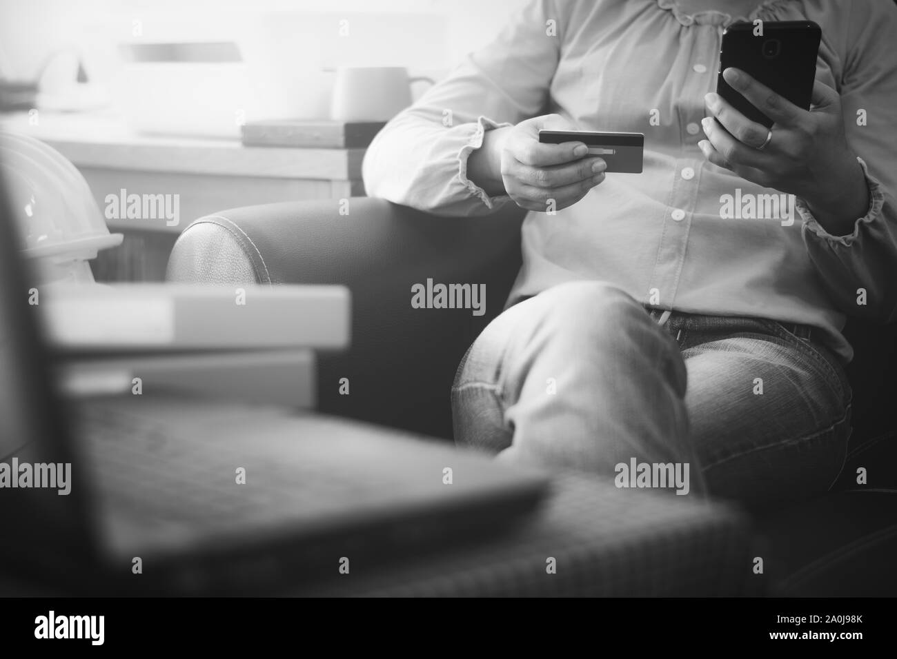 Donna in camicia casual pagando con carta di credito online mentre si effettuano ordini via Internet. Imprenditrice di successo rendendo la transazione tramite il telefono cellulare. Foto Stock