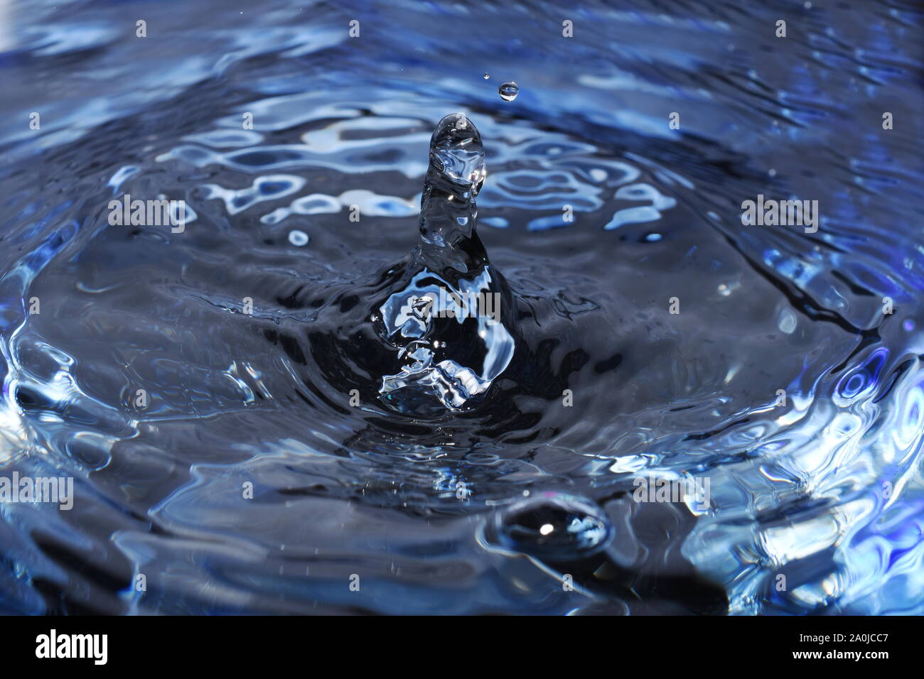 Splash e ondulazioni in nero e blu liquido Foto Stock