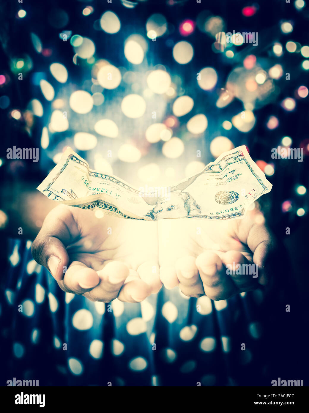 Mani di strega in una stanza buia a rievocare una magia con US Dollar nota è flottante sulle mani Foto Stock