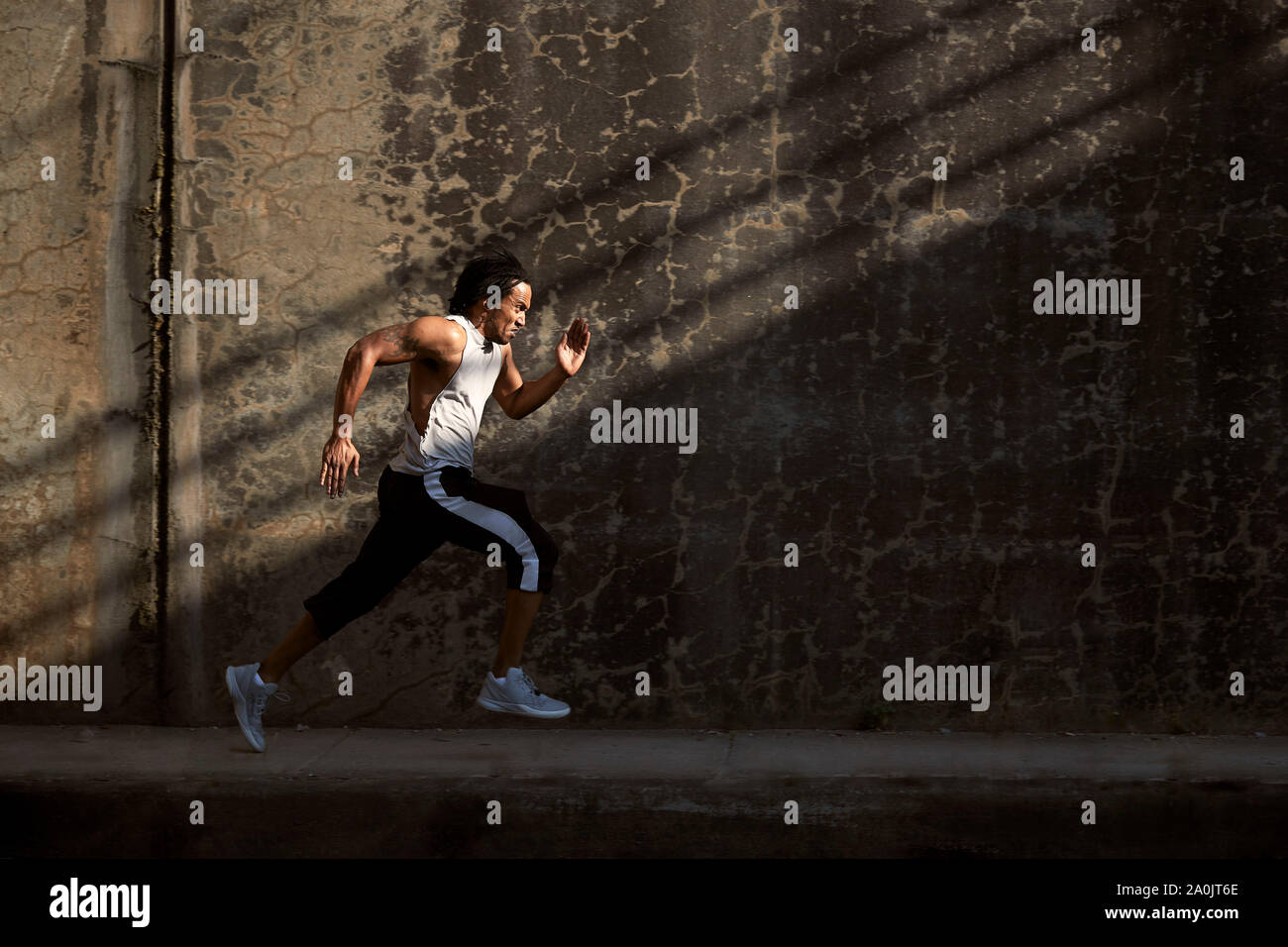 Afro-americano di uomo che corre sul marciapiede Foto Stock