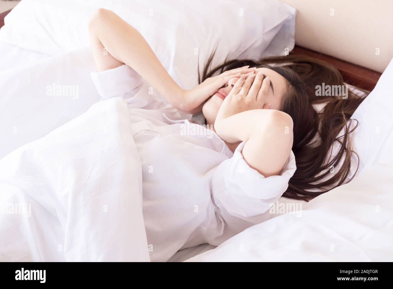 Giovane donna non può dormire. sul suo letto e pensare Foto Stock