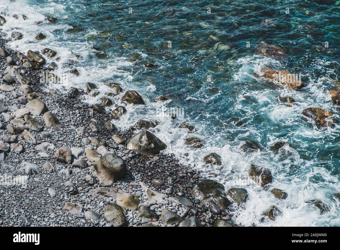 Costa dell'oceano surf con le rocce in ciottoli beach Foto Stock