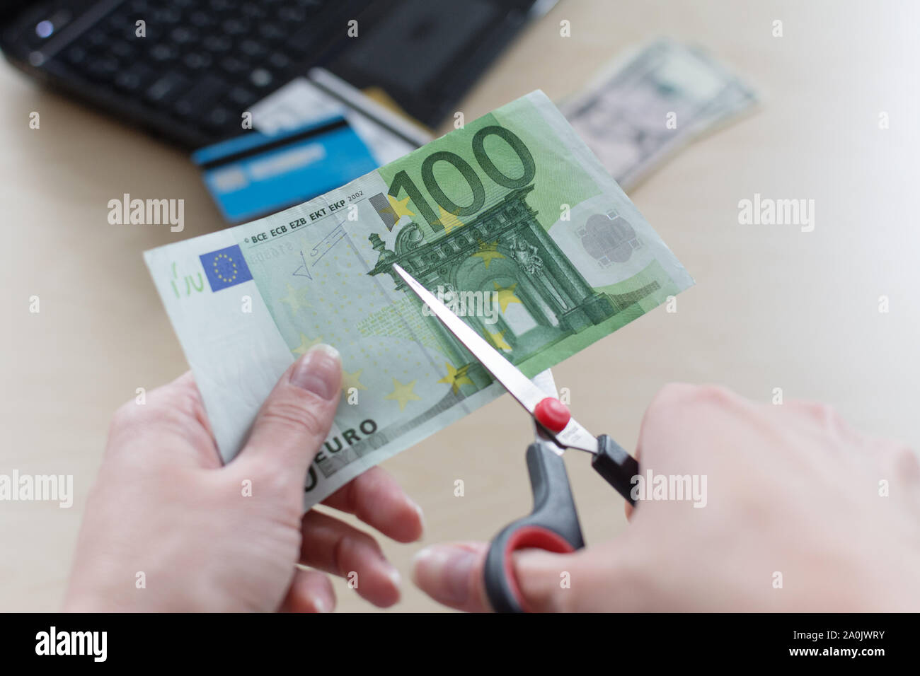 Il taglio di banconote in euro con una forbice, tagliare budget, ridurre i costi. I tassi di interesse del concetto. Foto Stock