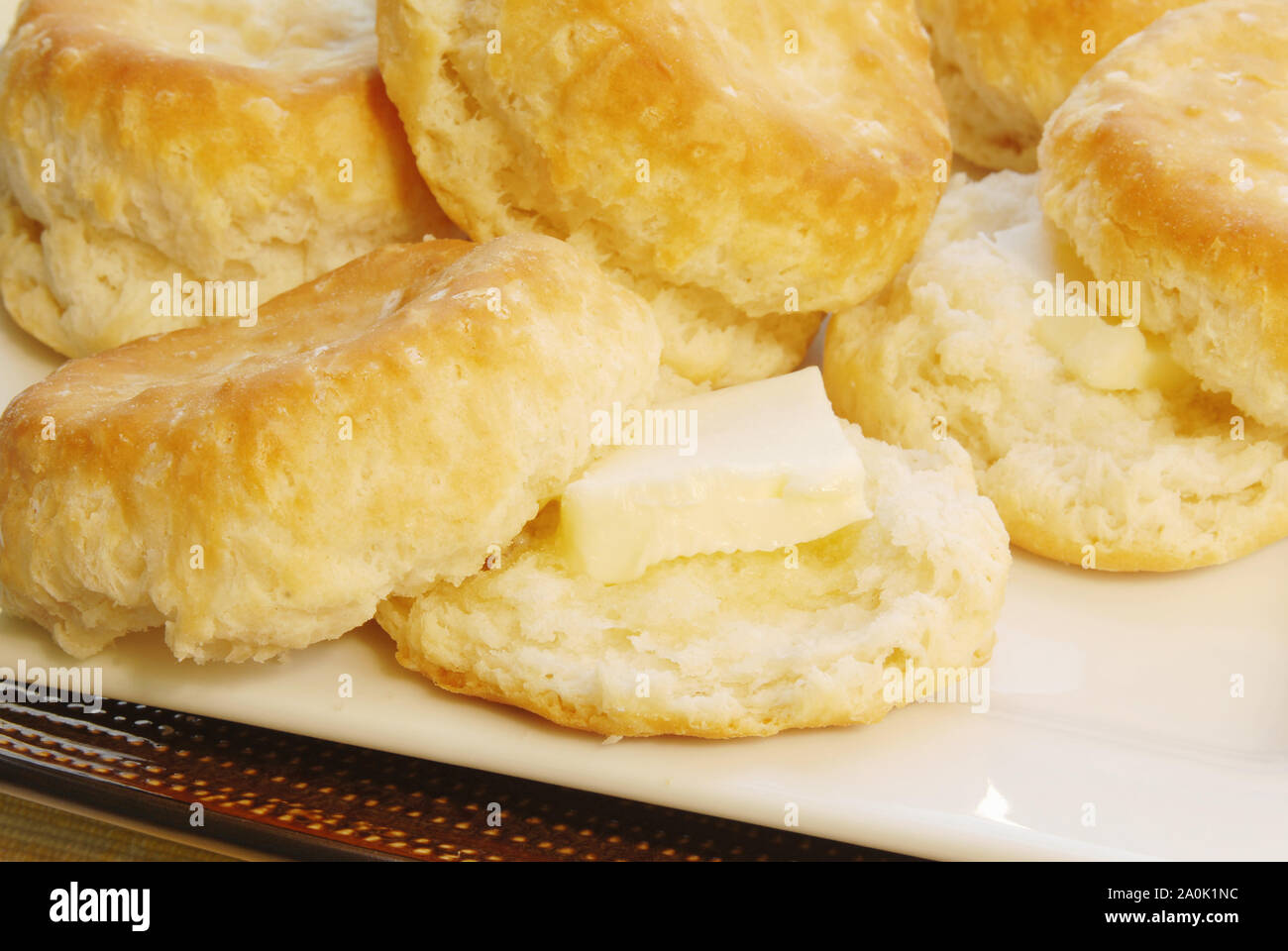 In casa cotta negli Stati Uniti meridionali latticello biscotti con panetti di burro su quelli che vengono tagliati. Foto Stock
