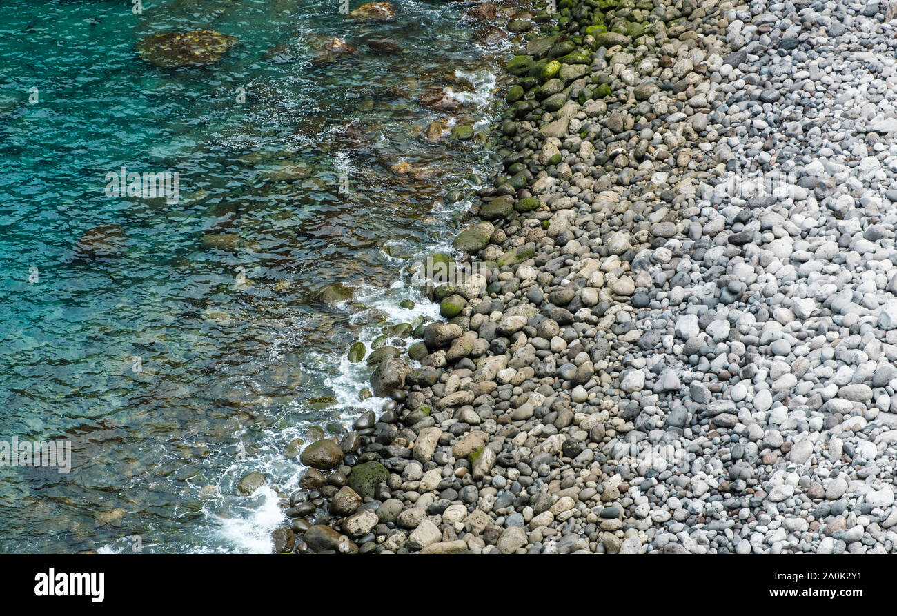 Spiaggia di pietra, di ghiaia pietre sulla costa dell'oceano - sullo sfondo della natura Foto Stock
