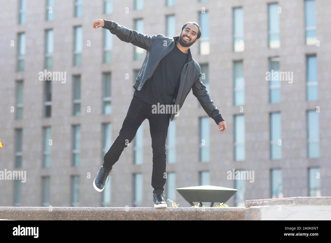Giovane uomo essere felice in equilibrio su una parete Foto Stock