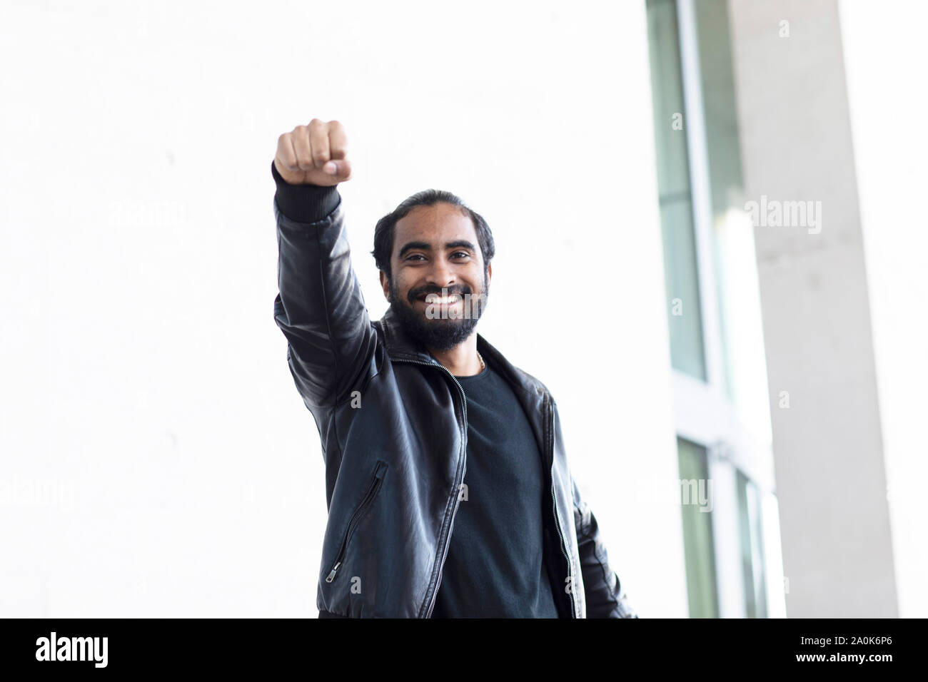 Giovane uomo come con braccio di superman prima di un edificio Foto Stock