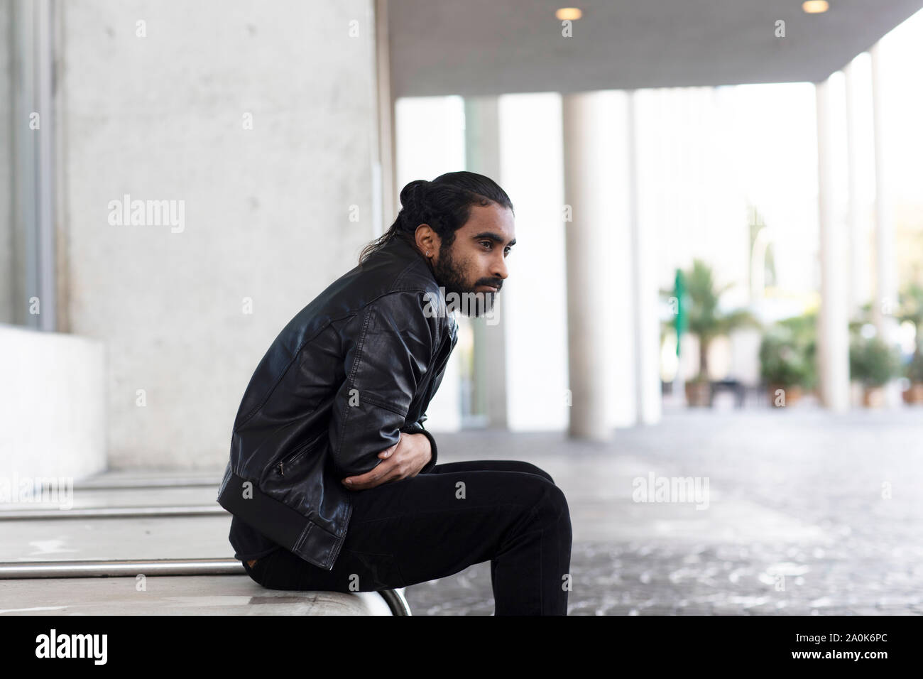 Giovane uomo seduto fuori ed essere frustated Foto Stock