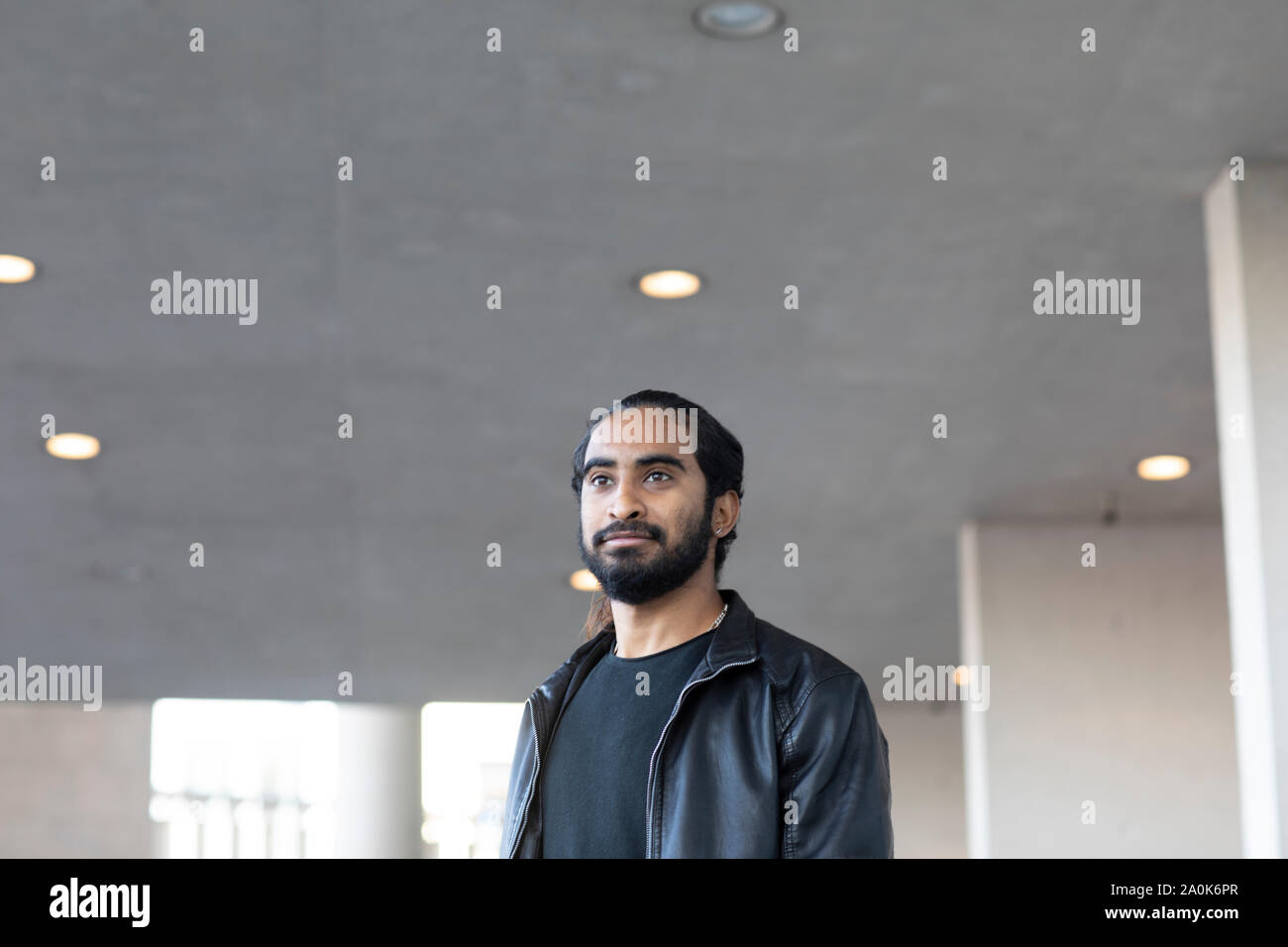 Giovane uomo a camminare sotto un soffitto Foto Stock
