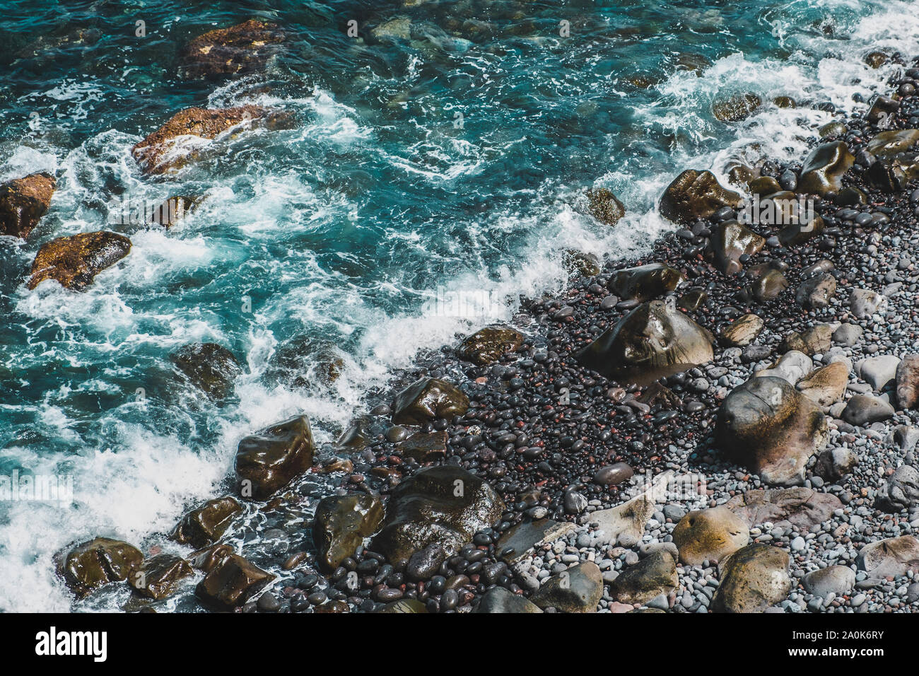 Acqua su pietre - oceano onde sulla spiaggia di pietra Foto Stock