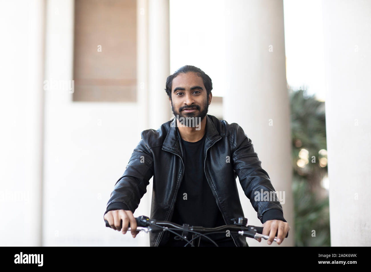 Giovane uomo percorsi in bicicletta in città Foto Stock