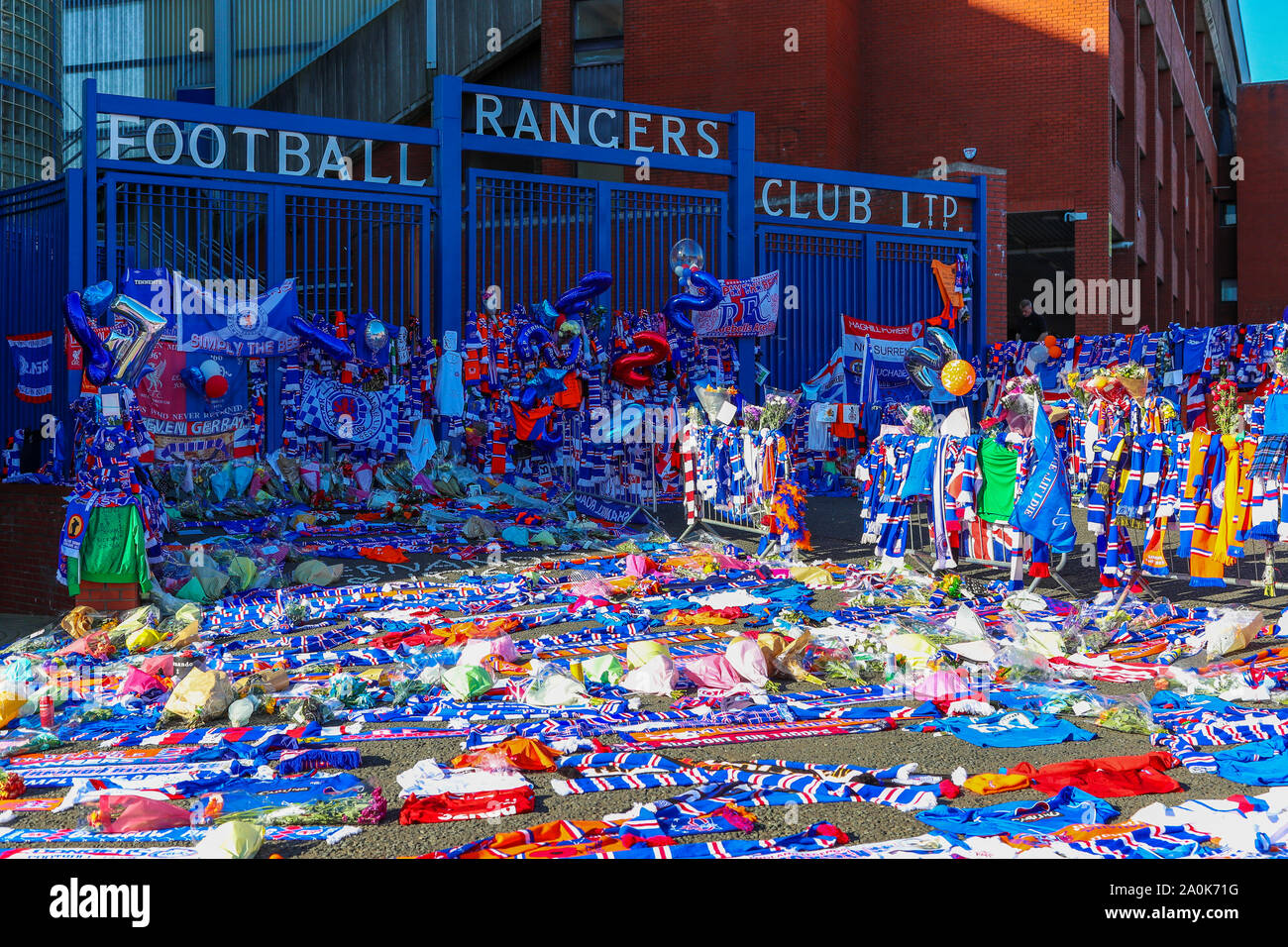 Glasgow, Regno Unito. Xx Settembre, 2019. Omaggi compresi fiori, sciarpe, calcio tops, schede e torte sono state lasciate al Broomloan Road e Copland Road porte di Ibrox Football Stadium, casa di Glasgow Rangers nel rispetto per FERNANDO RICKSEN, olandese calciatore internazionale che ha suonato per i Rangers e chi è morto di neuroni motore malattia (MND) il 18 settembre 2019, di anni 43. Credito: Findlay/Alamy Live News Foto Stock