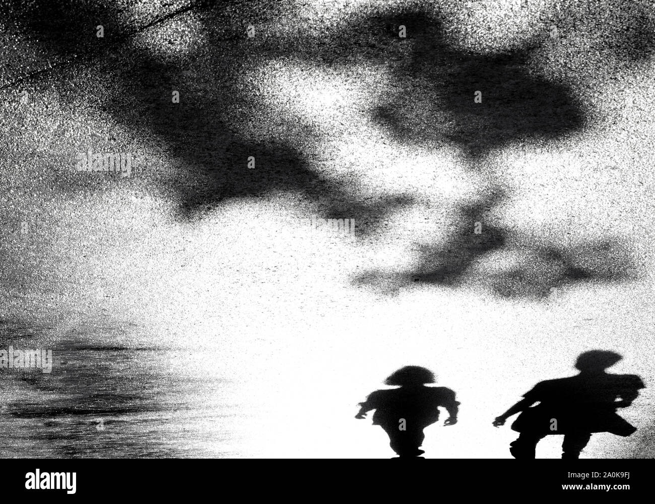 Sfocata ombra silhouette di due giovani passeggiate nel parco della città in alto contrasto bianco e nero Foto Stock