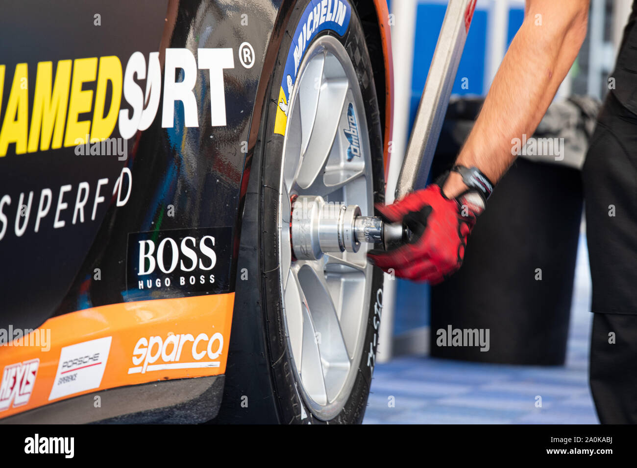 Circuito di Vallelunga, in Italia il 14 settembre 2019, ravvicinata di una parte del corpo umano che fissano racing auto ruota nel paddock Foto Stock