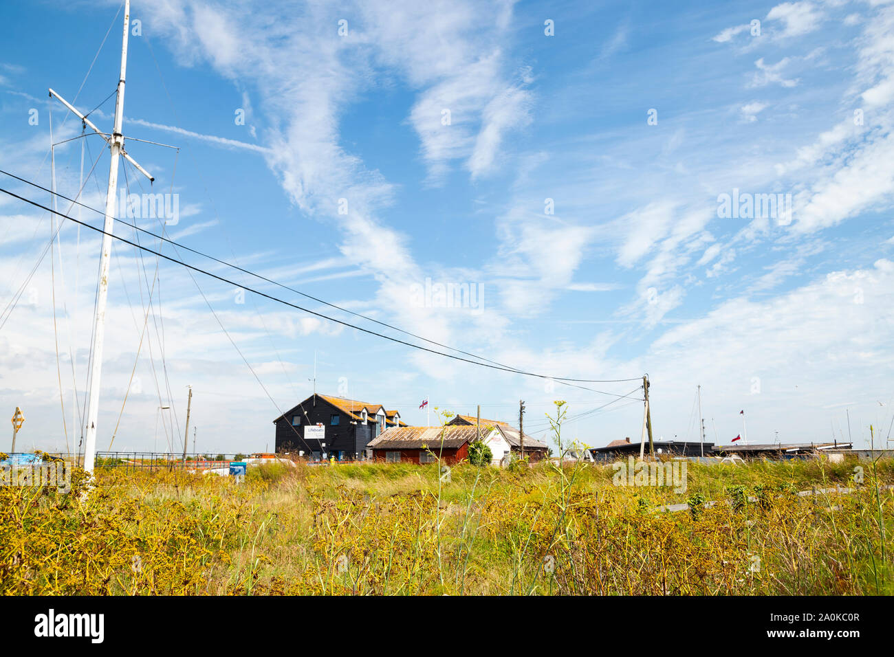 Segale, East Sussex, Regno Unito - 27 Luglio 2019: una panoramica, vista pittoresca del porto di segale edifici con belle blu cielo nuvoloso ed erba selvatica Foto Stock