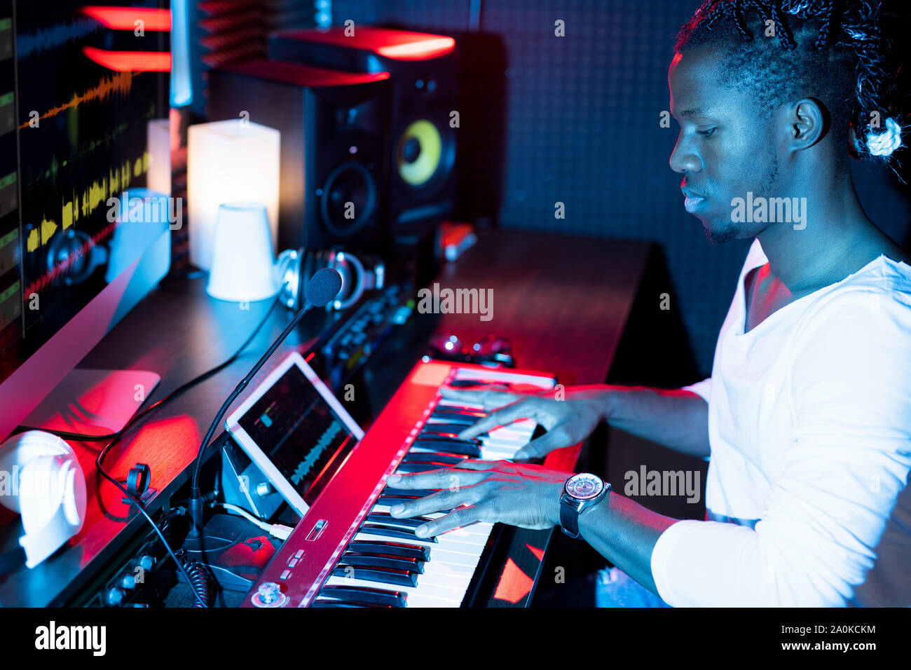 Giovani gravi afro-americano rendendo nuova musica mentre è seduto in studio Foto Stock