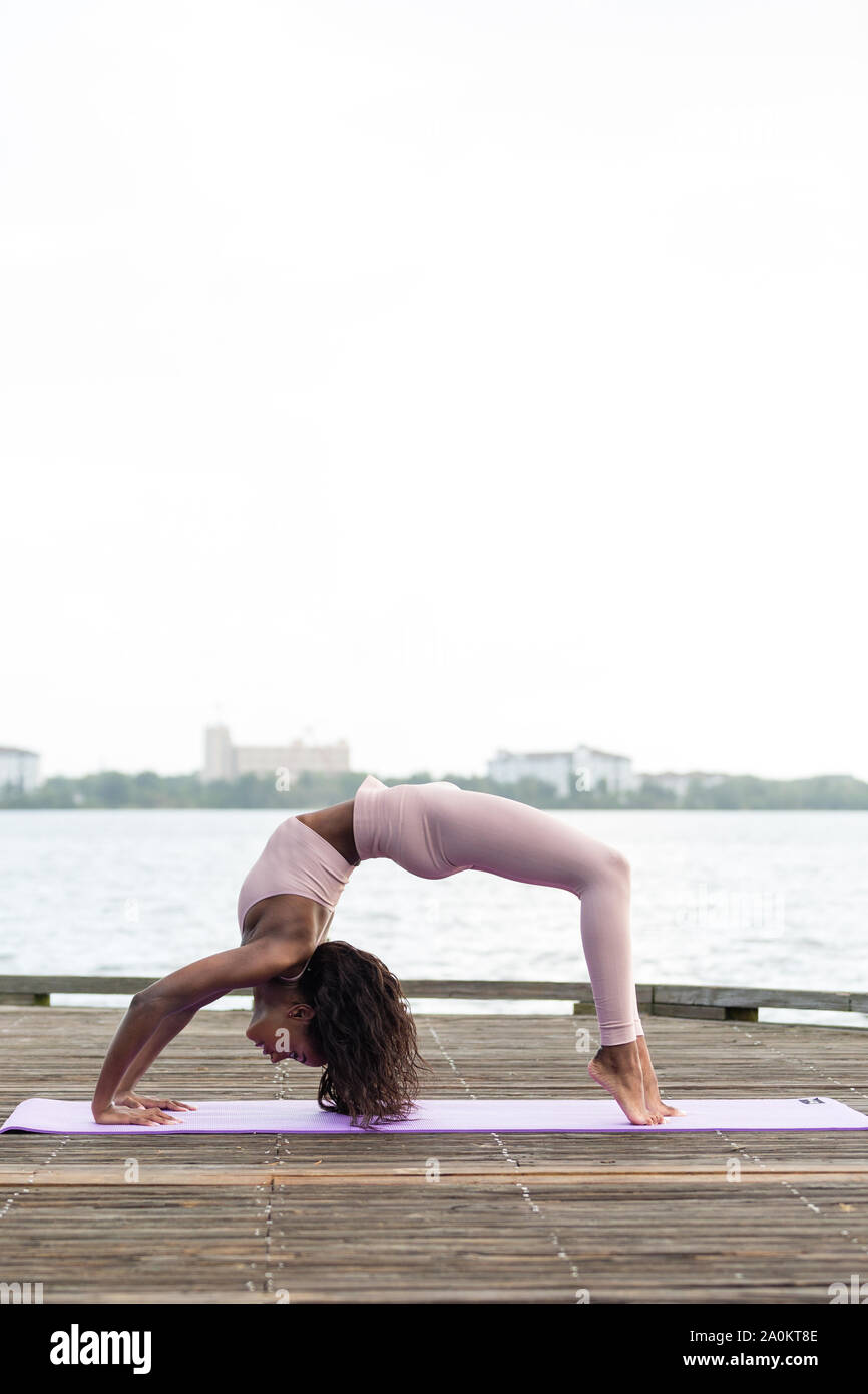Tara facendo la mattina presto lo yoga al di fuori su di un giorno di estate Foto Stock