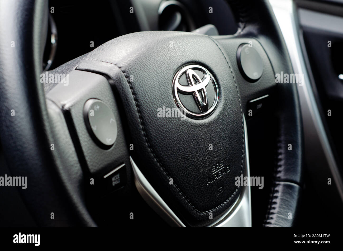 Il logo della Toyota al volante di una Corolla berlina sportiva di salita. Foto Stock