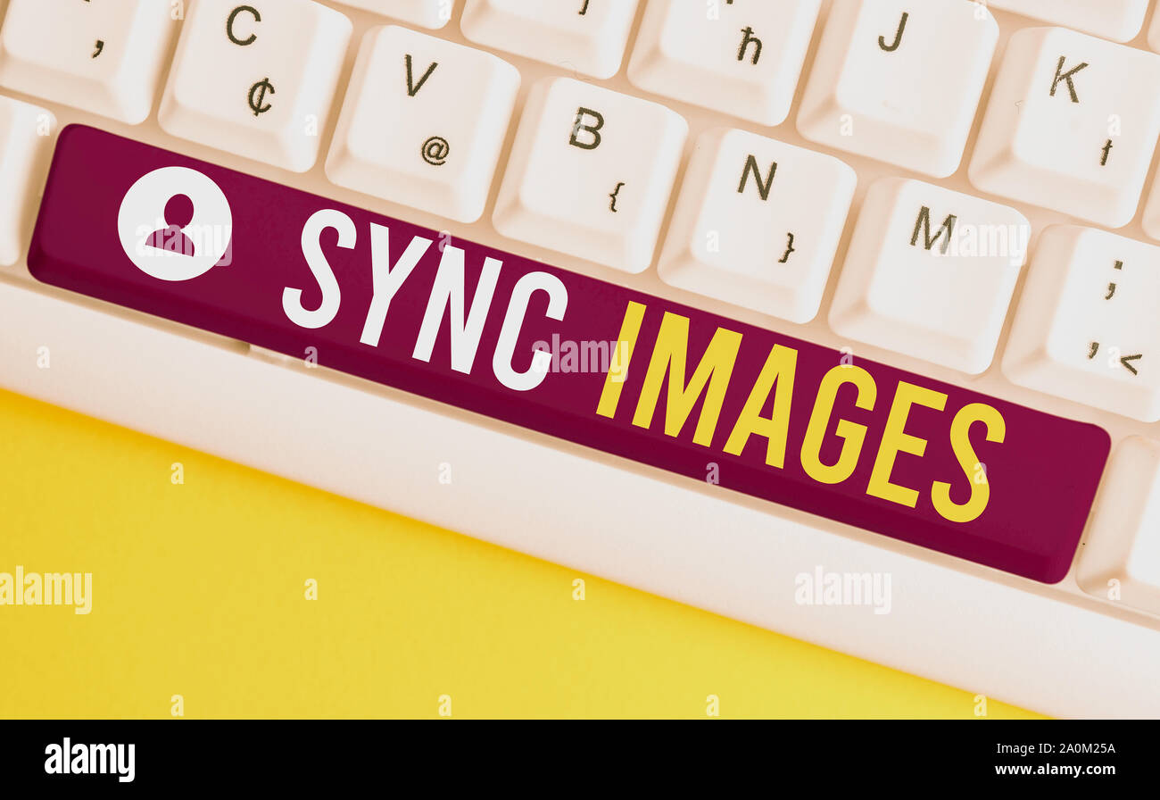 Parola di scrittura di testo sincronizzare le immagini. Business photo vetrina per fare foto identiche in tutti i dispositivi accessibili ovunque bianco tastiera PC con nota vuota Foto Stock