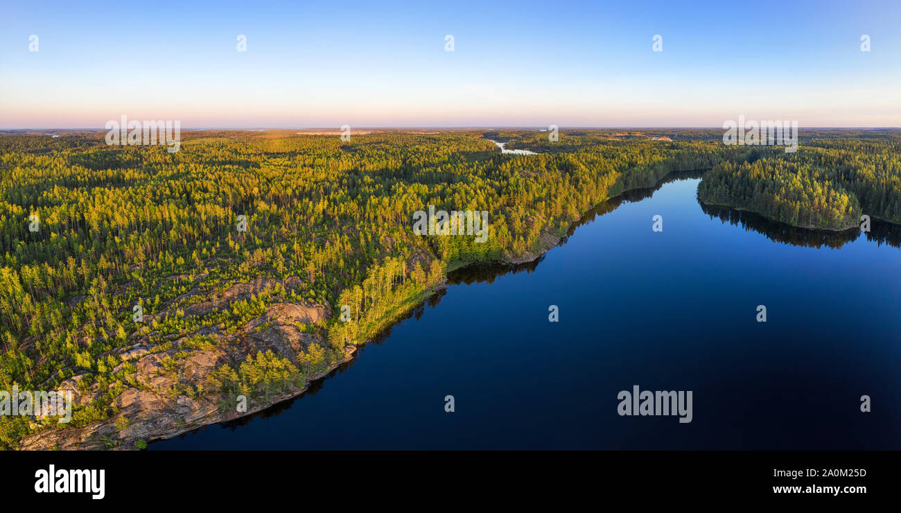 Infinite antenna di bosco vista panoramica. Profonda foresta selvaggia e chiaro lago blu al tramonto Foto Stock