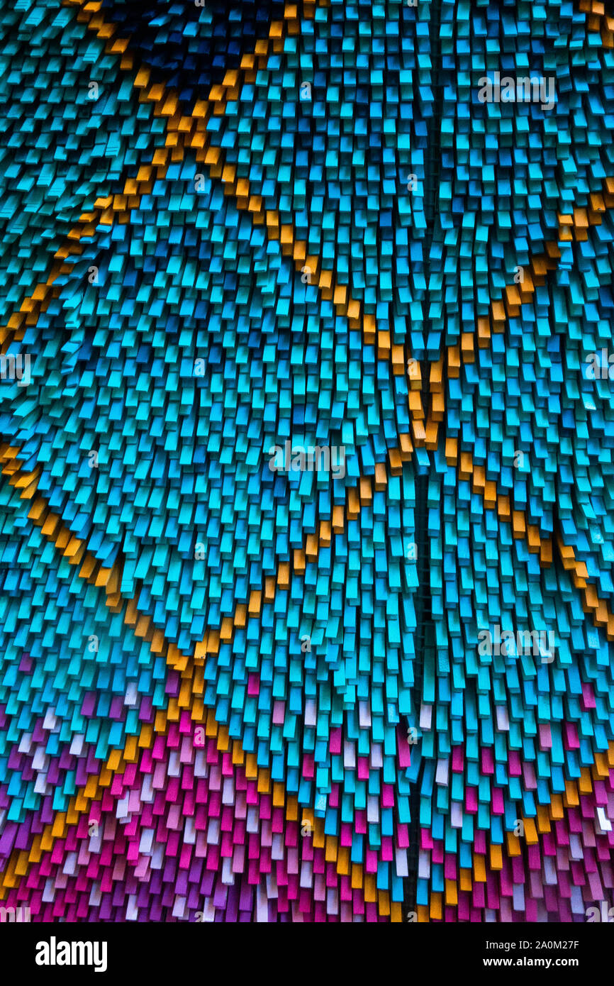 Sfondo astratto di piccole aste verticali colorate in plastica o legno che formano un motivo geometrico testurizzato con sfumature blu arancio e viola Foto Stock