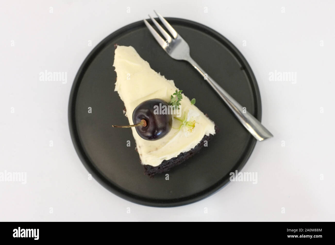 Birra nera torta. Un pezzo di torta nera con sapore di birra e rabboccato con crema di formaggio e di ciliegio Foto Stock