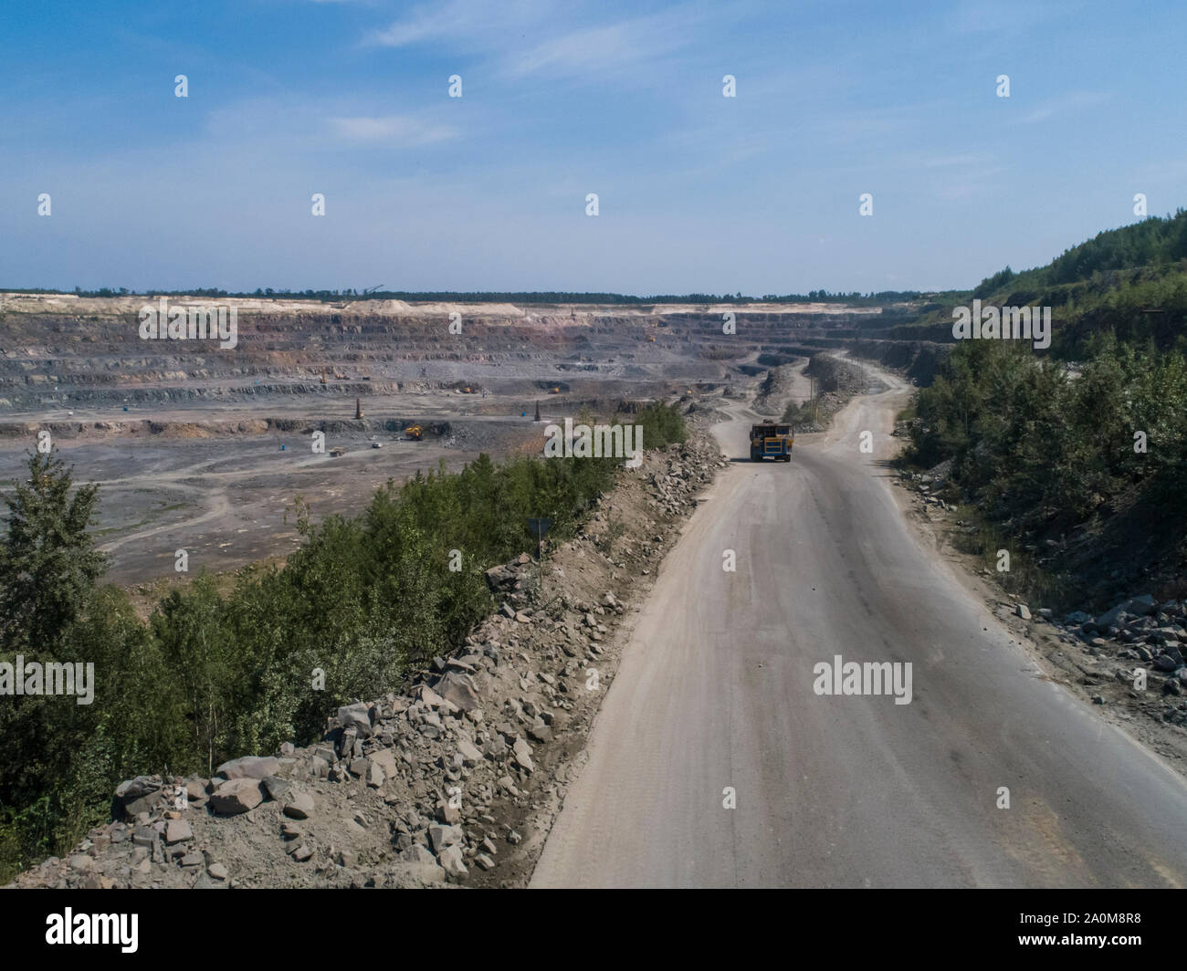 Industriale enorme camion in una grande cava di pietra caricato il trasporto di marmo o granito sparato da un drone Foto Stock