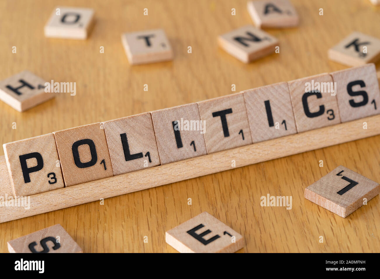 Lettere di legno codificate su un rack che scrivono la parola politica. Concetto: Politica di partito, sistema politico, governo, legislazione, democrazia Foto Stock