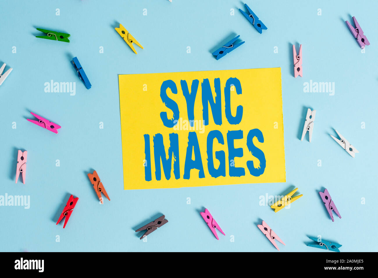 Testo della scrittura sincronizzare le immagini. Foto concettuale rendendo le foto identiche in tutti i dispositivi accessibili ovunque clothespin colorate a forma di rettangolo promemoria Foto Stock