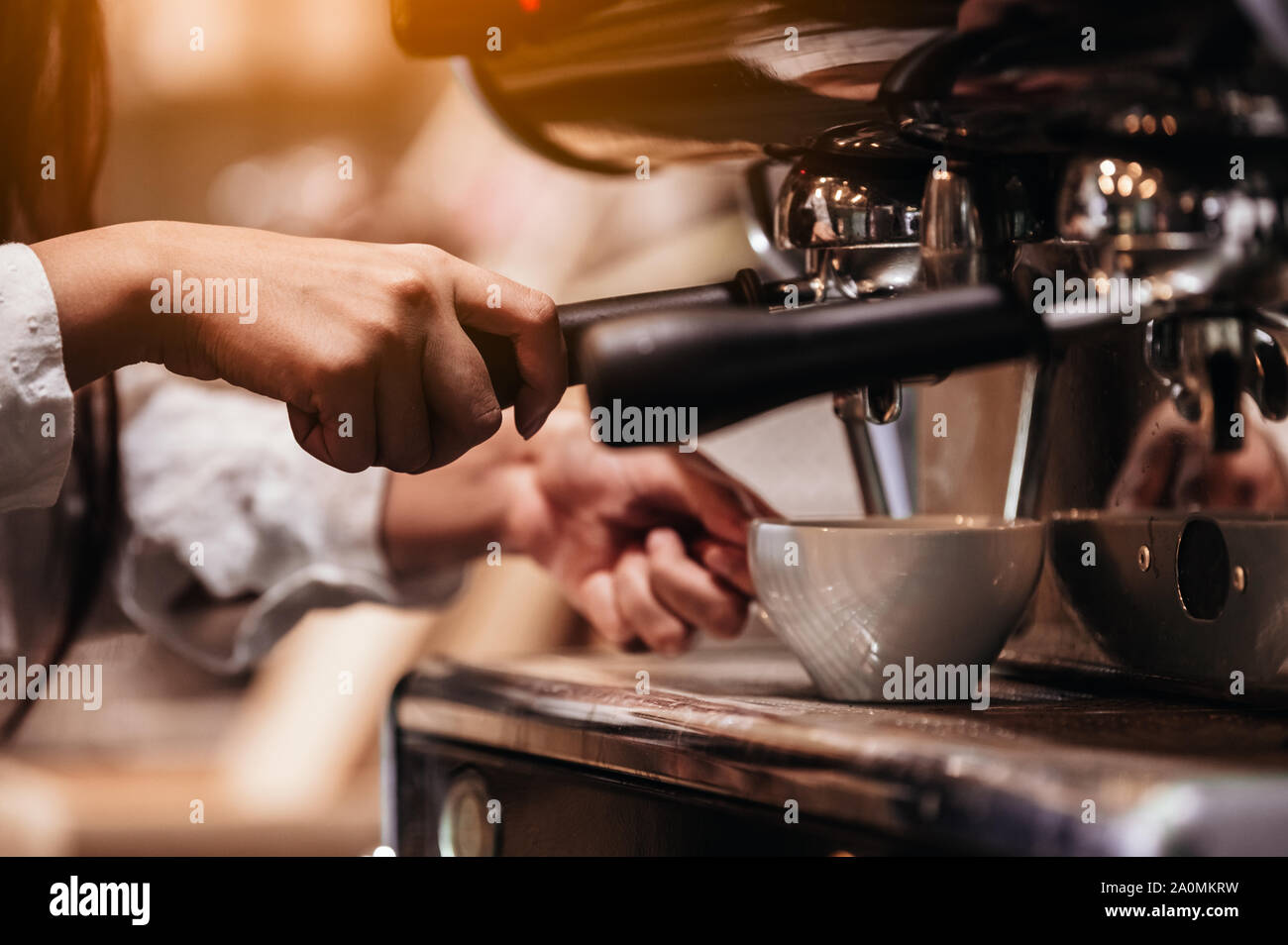 Primo piano della femmina professionale barista mano rendendo tazza di caffè con macchina per il caffè macchina nel ristorante o negozio di caffè. Persone e stili di vita. Busine Foto Stock