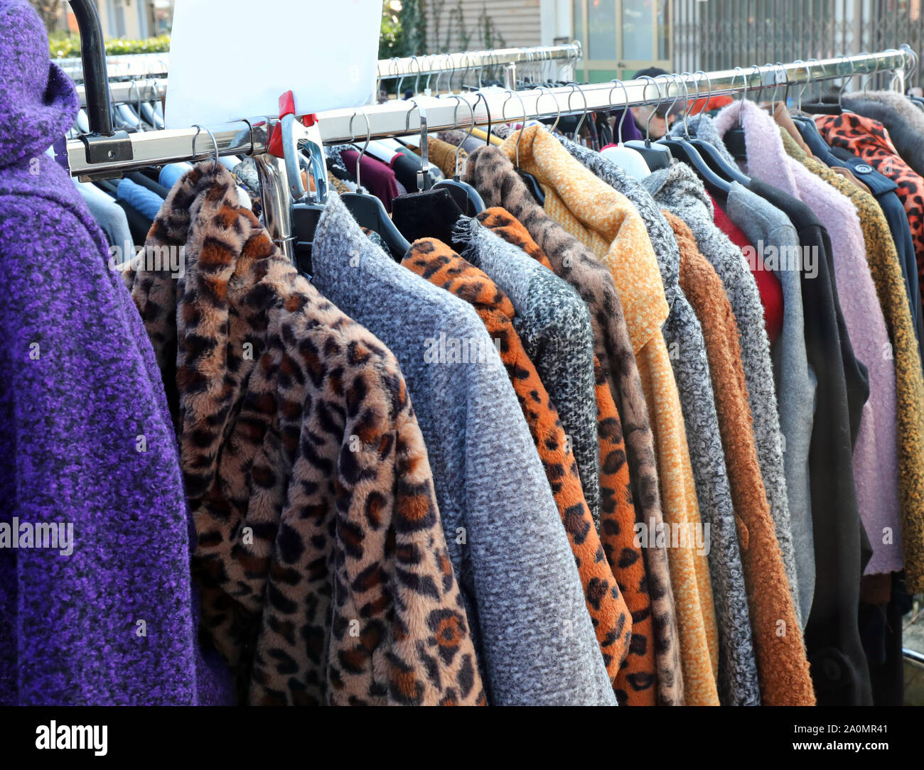I vestiti e le pellicce appesi al mercato all'aperto in stallo in inverno Foto Stock