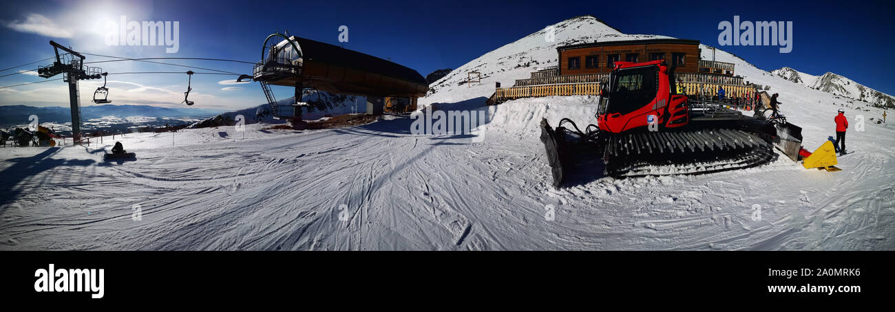 Inverno vista panoramica sulla località sciistica con gatto delle nevi in primo piano. Foto Stock