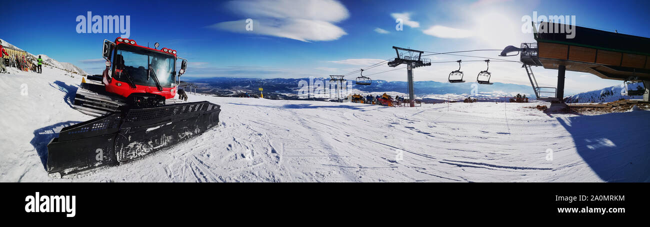 Inverno vista panoramica sulla località sciistica con gatto delle nevi in primo piano. Foto Stock