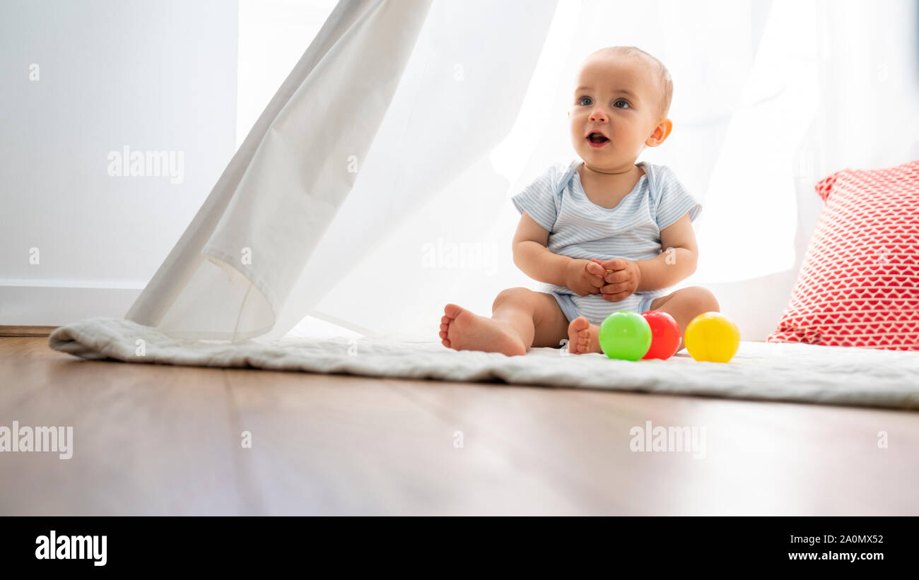 Bambino seduto in tenda e giocare con i giocattoli a casa Foto Stock