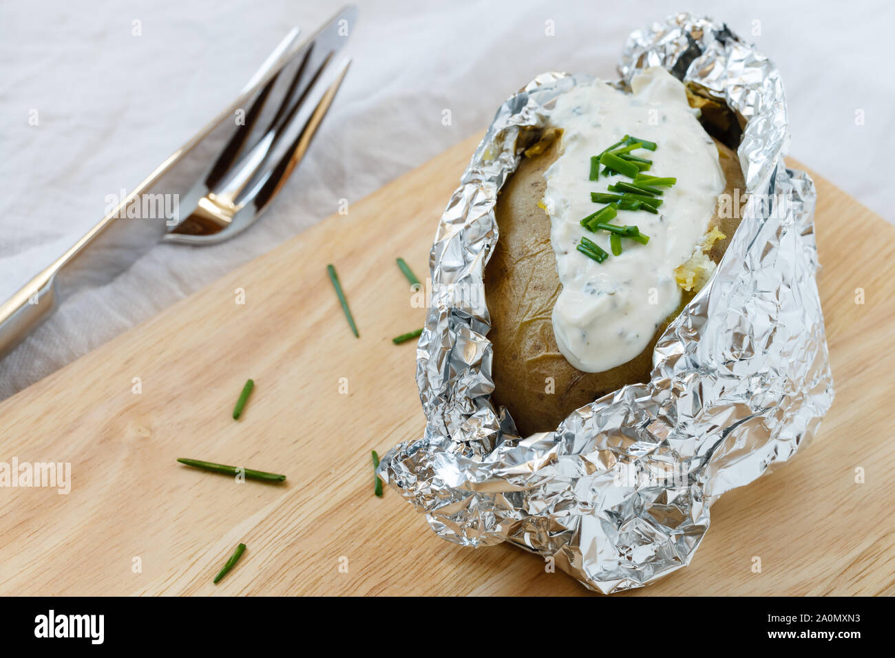 Cotta nel forno Potatoe con crema a base di erbe formaggio sulla tavola di legno Foto Stock