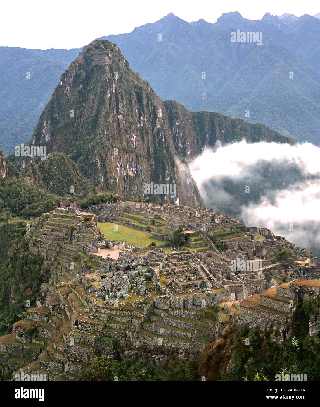 Machu Picchu è una cittadella Inca è impostata su un livello elevato nella catena delle Ande in Perù, sopra il fiume Urubamba valley. Costruito nel XV secolo e successivamente abbandonato, è rinomato per la sua sofisticata muretti a secco che il fusibile enormi blocchi senza l'uso di mortaio, intriganti edifici che giocare su allineamenti astronomici e viste panoramiche. Il suo esatto ex uso rimane un mistero. Esso si erge 7,970 piedi (2.430 metri sopra il livello del mare sul versante orientale delle Ande Foto Stock