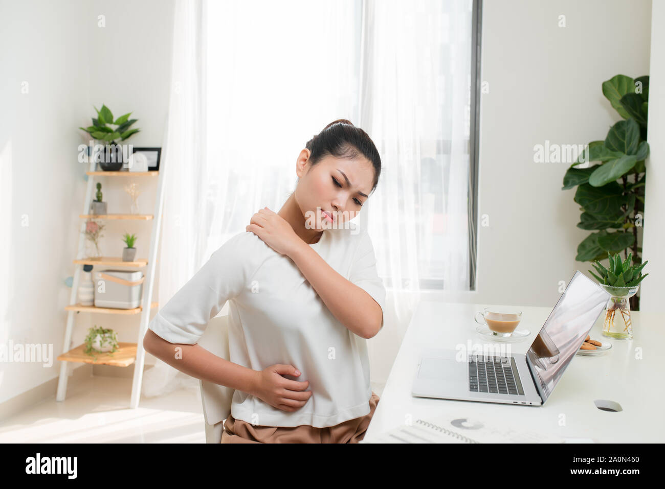 Giovane donna asiatica dolore alla spalla concetto alla sindrome di Office Foto Stock