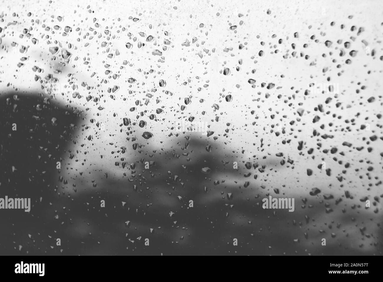 Le gocce di pioggia sul gradiente tonica vetro. Riflessioni sfocate Foto Stock