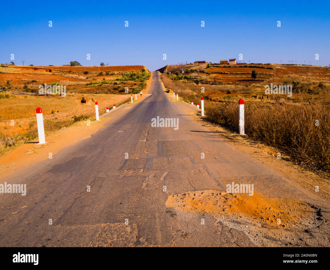 Panoramica strada lastricata di polverose buche che portano a Morondava, Madagascar Foto Stock