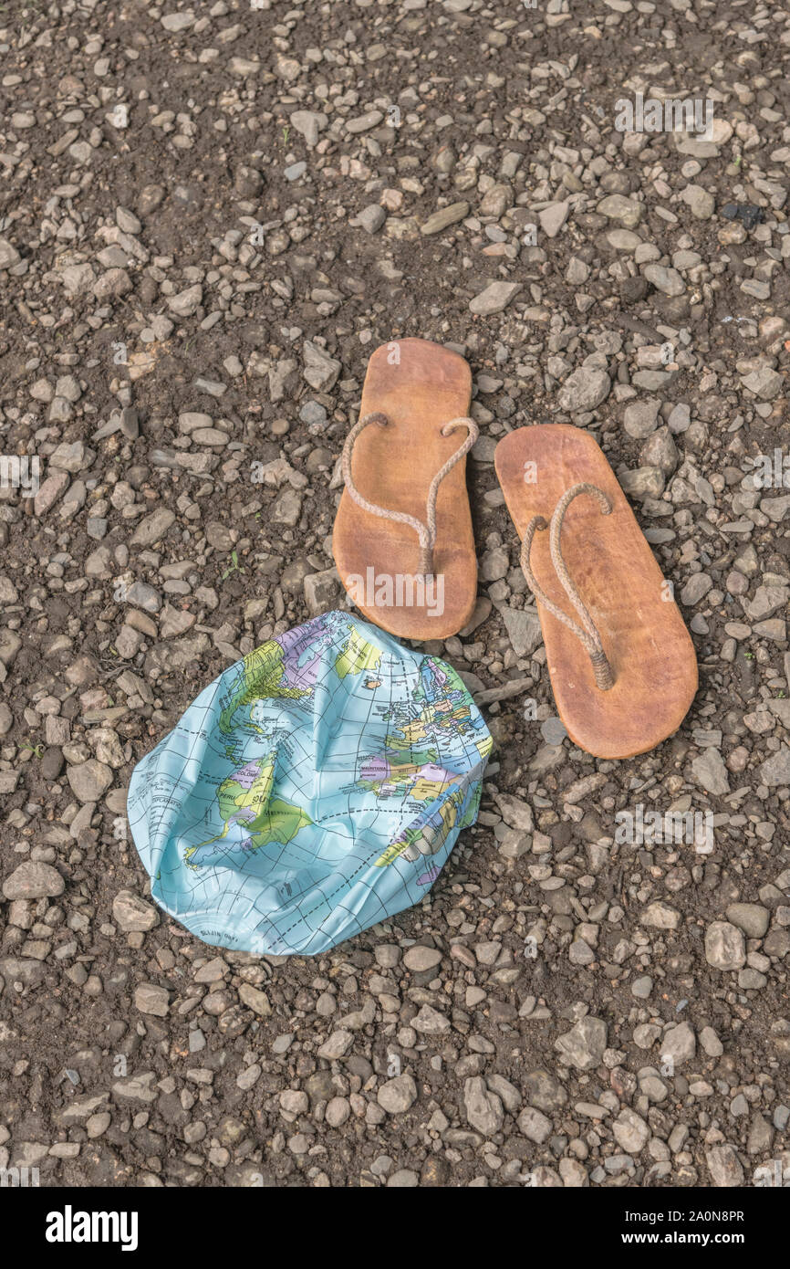 Indossato hippy flipflops & globo sgonfiato sulla superficie di scandole. Metafora terra piatta, flat earthers, teorie cospirative, piano terra prove, pseudoscience Foto Stock