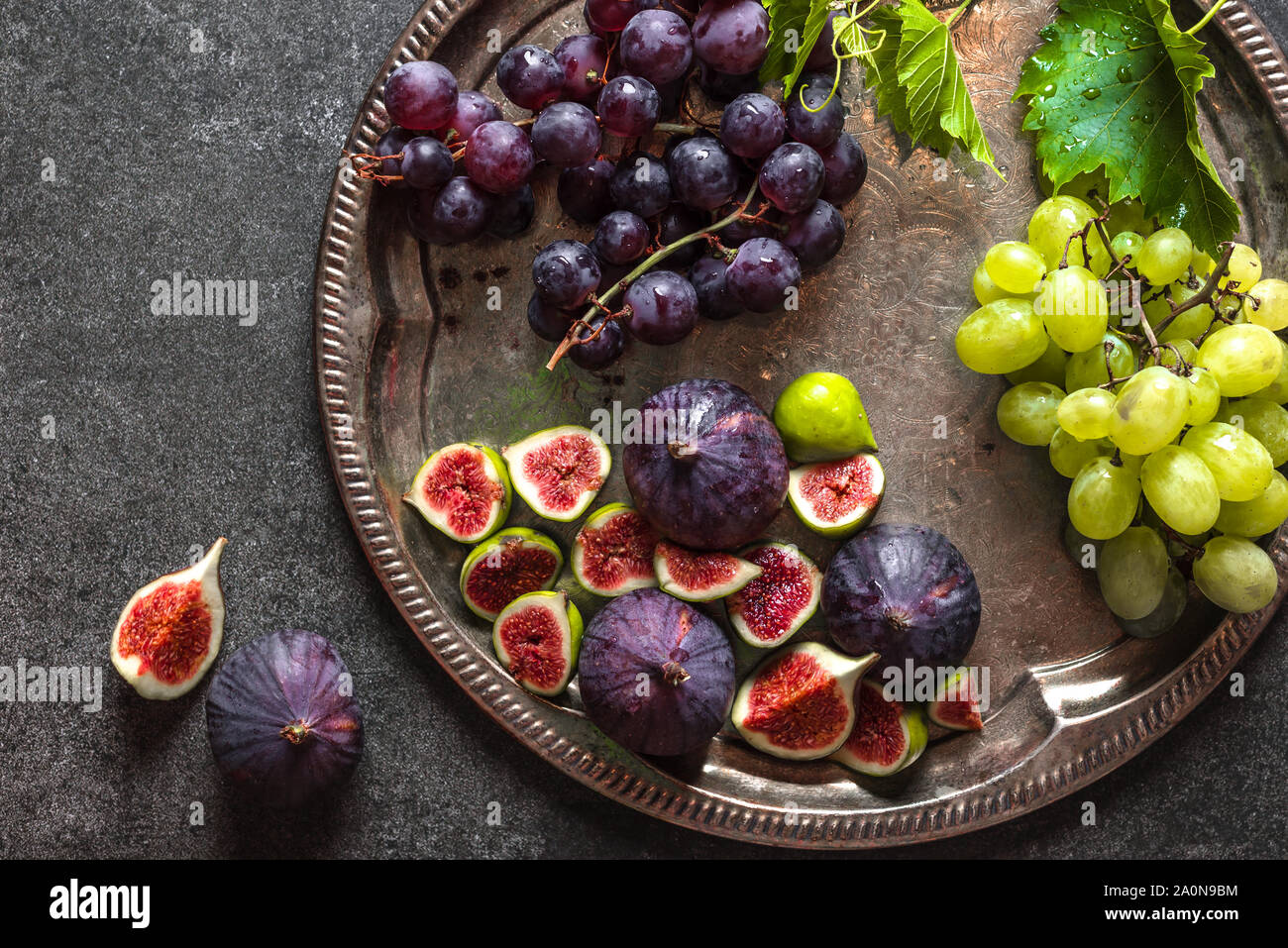 Bio frutta organica. Fichi freschi e uva. Un assortimento di frutta sul piatto di servizio di catering. Cibo per la condivisione. Foto Stock